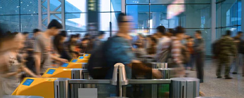 blurry people walking through turnstiles