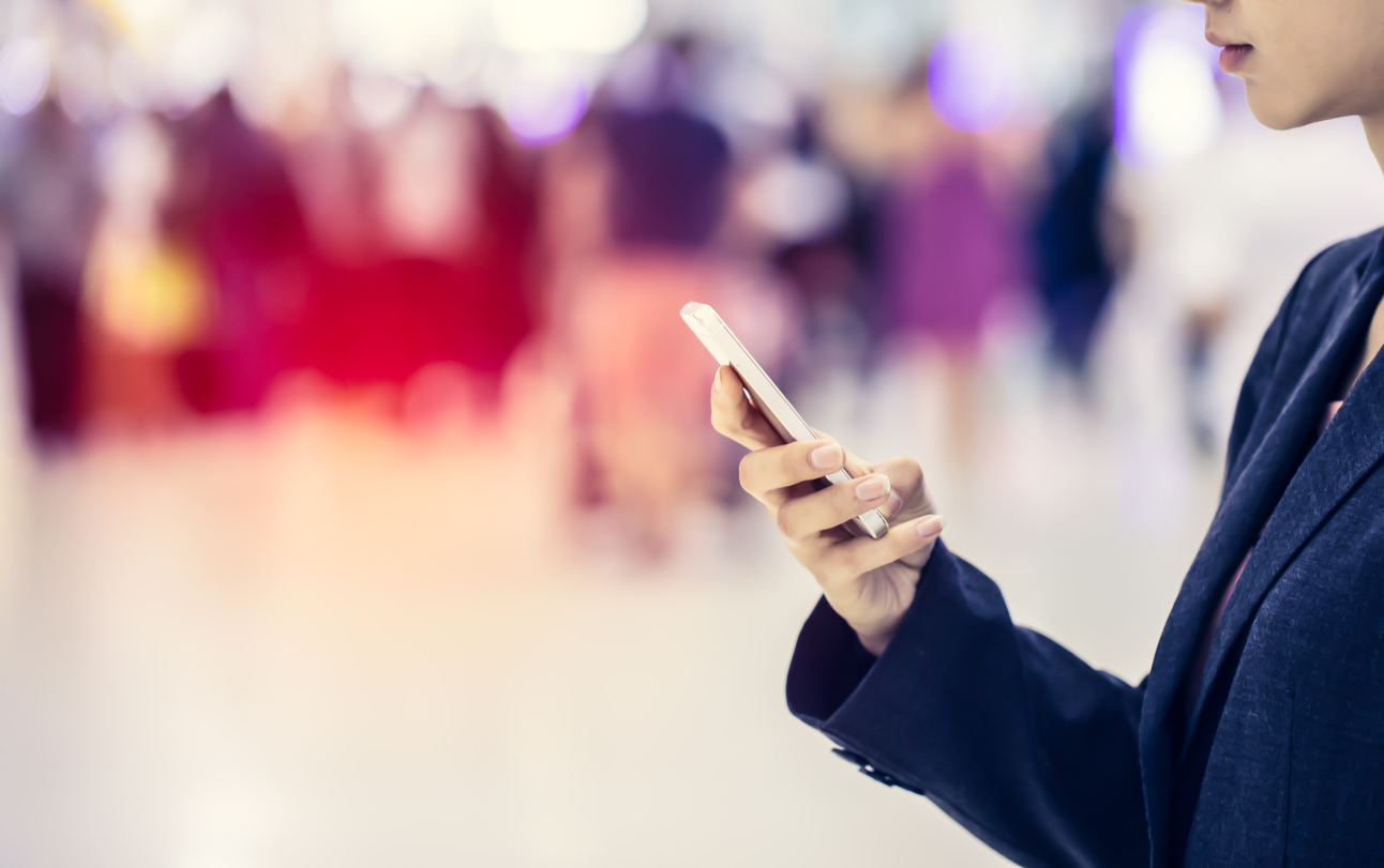 Woman looking at phone using UWB for untracked indoor navigation in a crowd