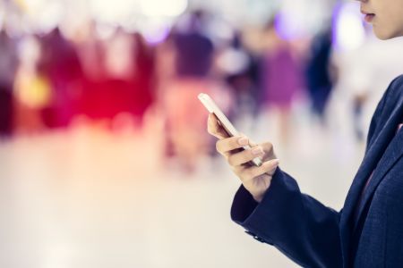 Woman looking at phone using UWB for untracked indoor navigation in a crowd